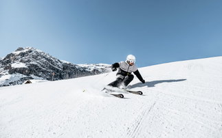 skifahrer auf piste carvt bergab mit head ski