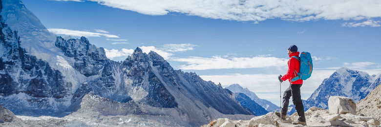 Man in outdoor clothing on the summit of a mountain.