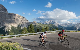 Two road cyclists on a road in the mountains