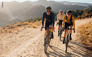 Radler auf Schotterstraße in der Sonne fahren auf Orbea E-Gravelbikes 