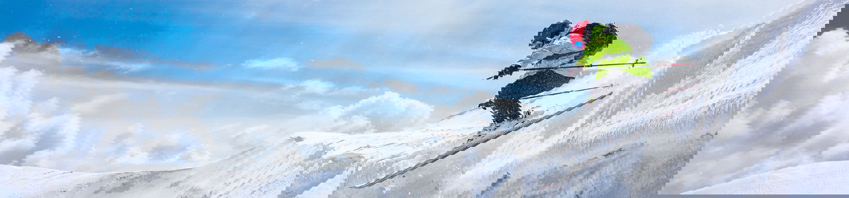 Freeski rider jumps over the slope in sunny weather