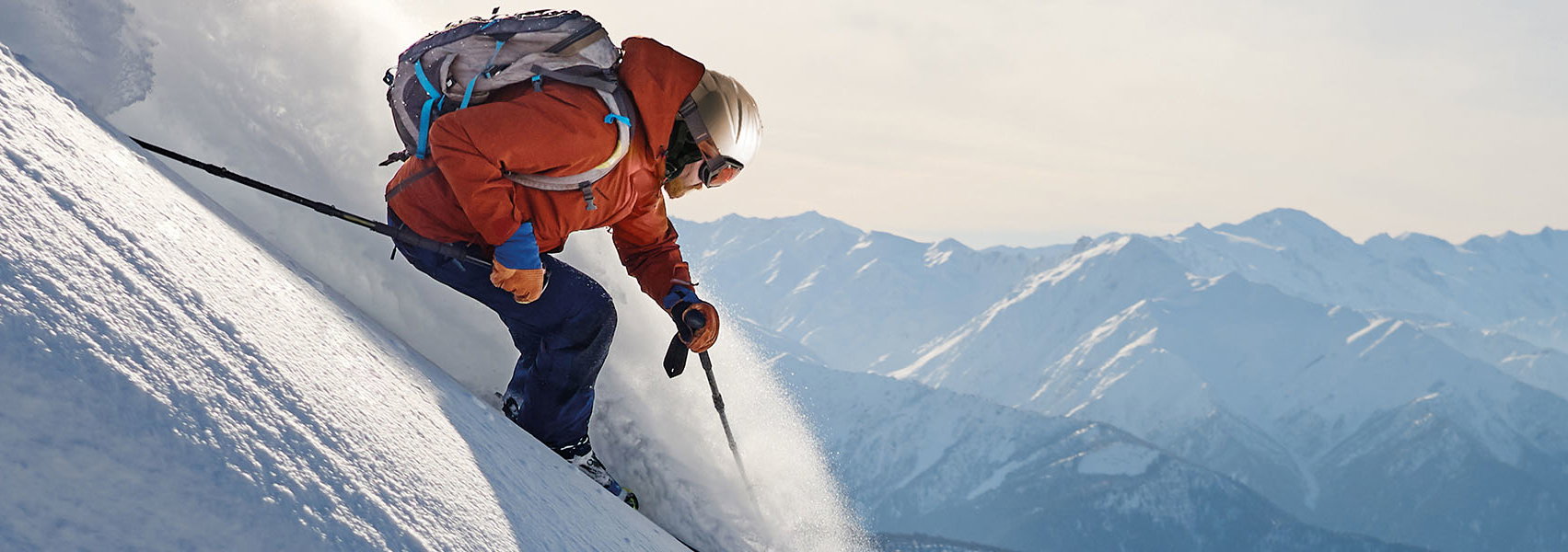 Freeski Fahrer springt über die Piste bei Sonnenschein