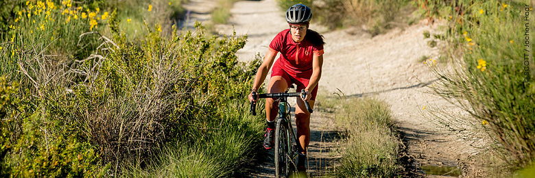 Radfahrerin mit Gravel Bike fährt durch die Natur