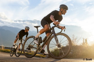 Zwei Rennradfahrer auf Scott-Bikes im Anstieg