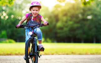 Mädchen mit pinkem Helm auf Fahrrad