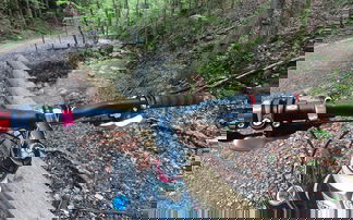 mountainbike lenker vor naturkulisse mit bach