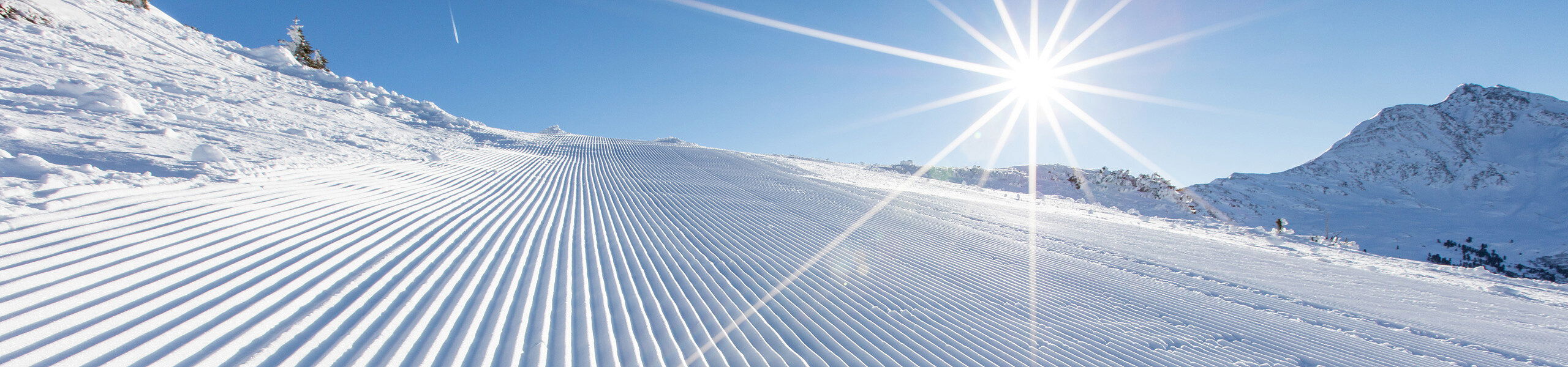 Präparierte Piste mit Berge im Hintergrund