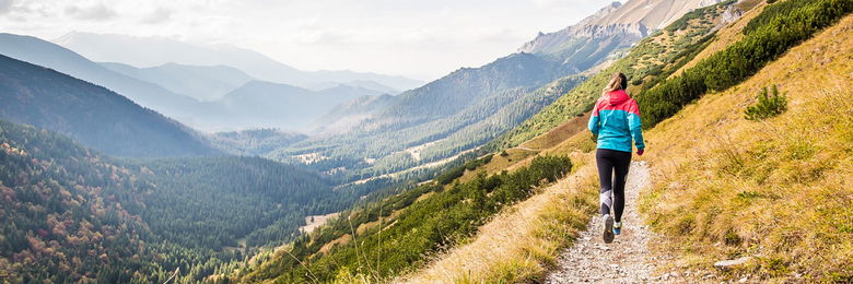 Frau läuft auf Trail in den Bergen