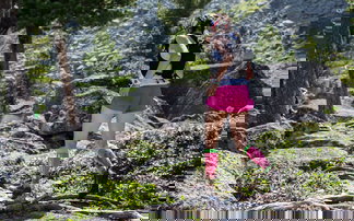 Frau läuft einen trail hinauf im wald