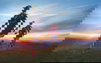 zwei läufer laufen im Sonnenuntergang über eine Wiese