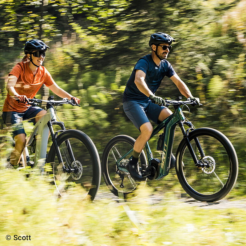 E-Bike Beratung Blogbeitrag: Zwei E-Biker fahren durch die Natur