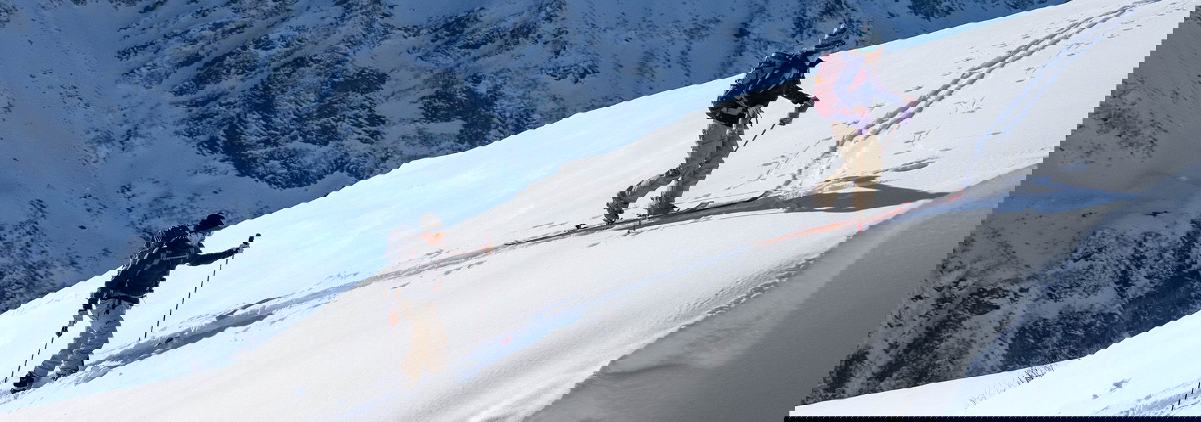 Zwei Tourenskifahrer gehen eine Skispur herauf